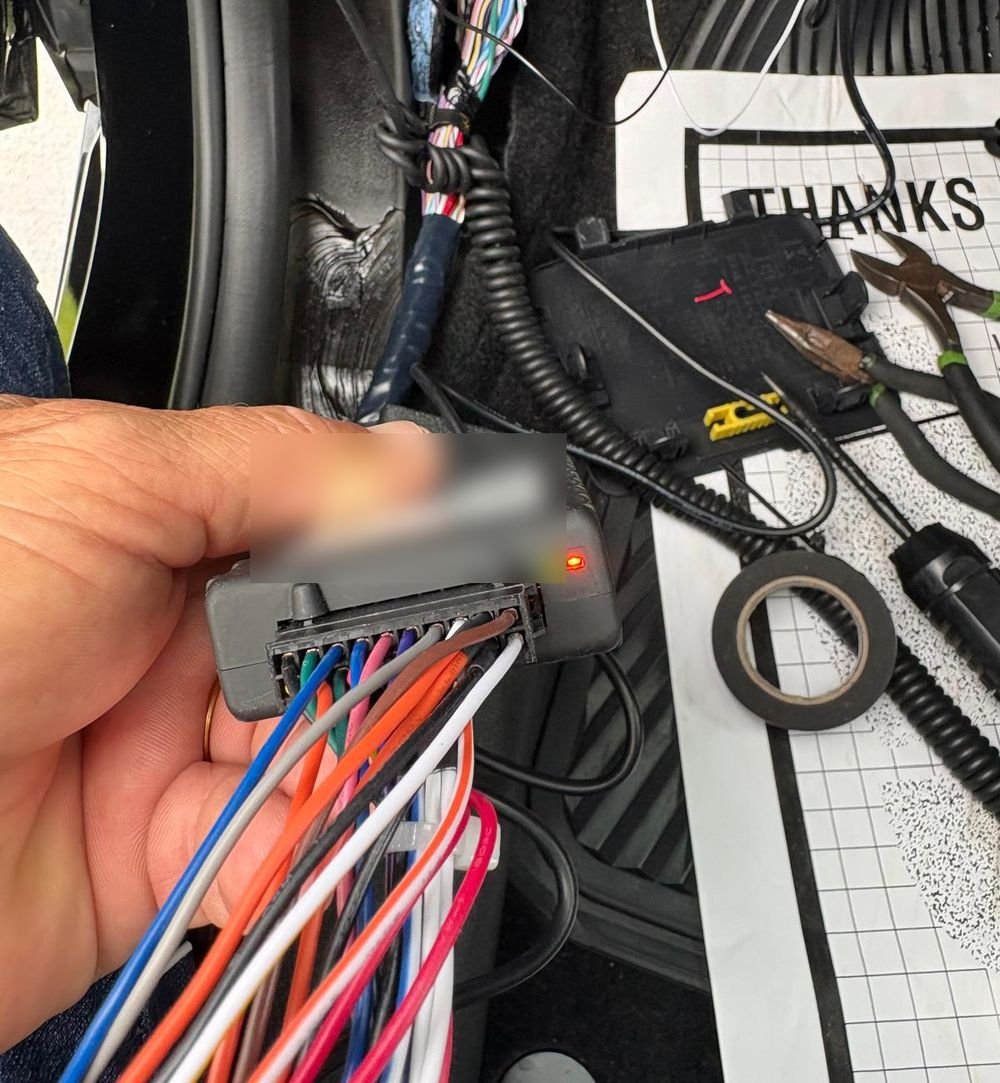 Hardwired GPS tracker being installed under the dashboard